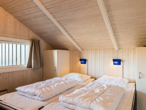 zwei Betten in einem Zimmer mit Holzwänden in der Unterkunft Bright Dune View Cottage-By Traum in Bjerregård