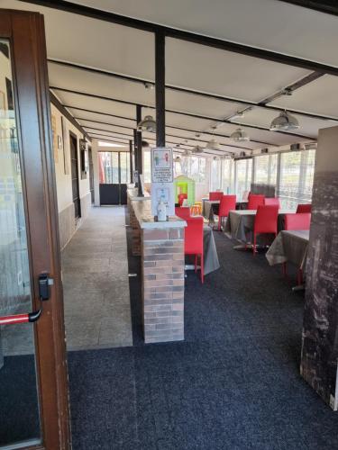 a large room with tables and red chairs at La Boheme SMART Hotel in Turin