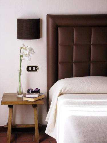 a bedroom with a bed and a table with a vase of flowers at La Locanda Della Chiocciola in Orte