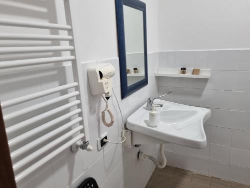 a white bathroom with a sink and a mirror at La Boheme SMART Hotel in Turin