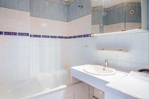 une salle de bain blanche avec un lavabo et un miroir dans l'établissement La Lagune - Appartement vue mer Pléneuf-Val-André, à Pléneuf-Val-André