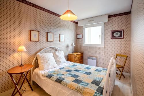 une chambre avec un lit, une table et une fenêtre dans l'établissement La Lagune - Appartement vue mer Pléneuf-Val-André, à Pléneuf-Val-André