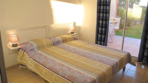 サリ・ソランザラにあるPALMERAIE 412- piscine en résidence-clim-wifiのランプ2つが付いた客室の大型ベッド1台