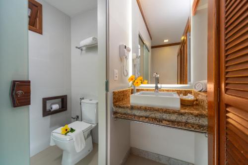 a bathroom with a white toilet and a sink at Quinta do Sol Praia Hotel in Porto Seguro