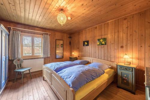 a bedroom with a bed in a room with wooden walls at Haus Löweneck in Bayrischzell