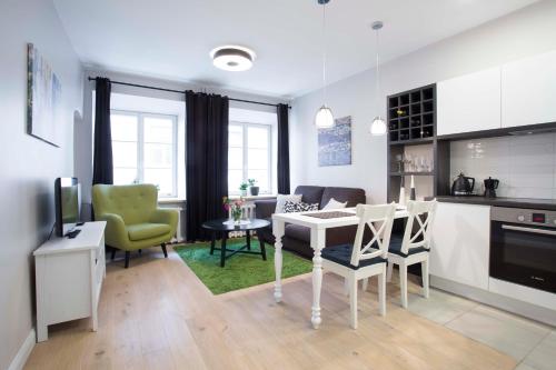 uma cozinha e sala de estar com mesa e cadeiras em Baron Old Town Apartments em Vilnius
