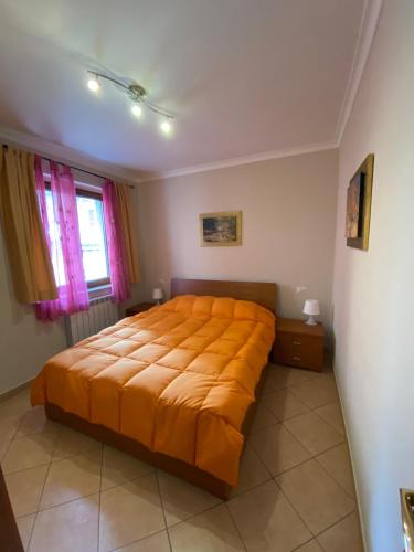 a bedroom with a large bed with an orange bedspread at Europa Casa Vacanze in Villetta Barrea