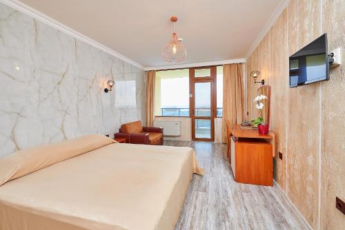 a hotel room with a bed and a television at Petar and Pavel Hotel & Relax Center in Pomorie