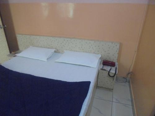 1 cama con sábanas blancas y almohadas en una habitación en Hotel Raj Guest House, en Jaipur