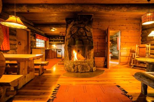 a living room with a fireplace in a log cabin at Kakslauttanen Arctic Resort - Igloos and Chalets in Saariselka