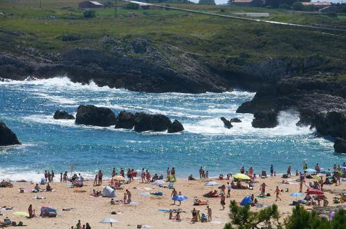 a group of people on a beach near the water at Posada La Morena in Soto de la Marina