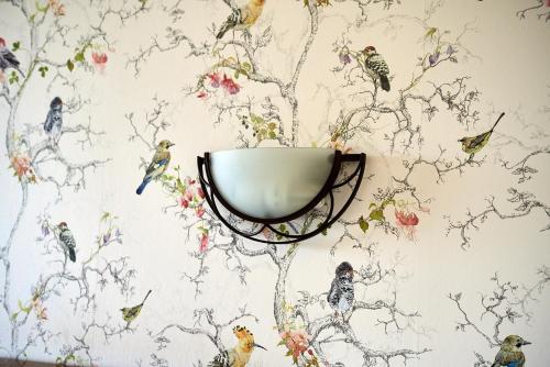 a wall mural of birds on a wall at Posada La Morena in Soto de la Marina