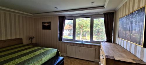 um quarto com uma cama e uma grande janela em Nida Kopu 3 Apartment em Nida