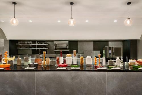 a kitchen with a counter with food on it at Ramada Encore by Wyndham Muscat Al-Ghubra in Muscat