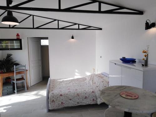 un salon avec un lit et une table dans l'établissement Le chalet du Bord de l'eau, à Sainte-Terre