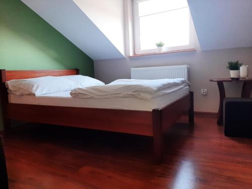 a bedroom with a large bed with a window at Smaczny Zakątek in Ruchocice