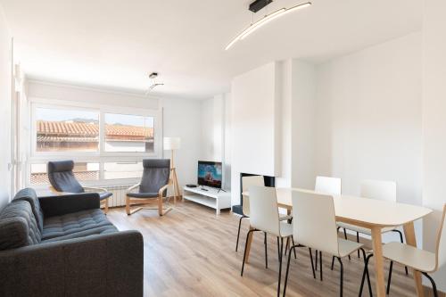 a living room with a table and chairs and a couch at Hauzify I Apartament Big Family in Sant Feliu de Guíxols