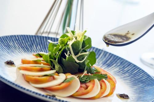 a plate of food with apples and greens on it at Vidam Hotel Aracaju - Transamerica Collection in Aracaju