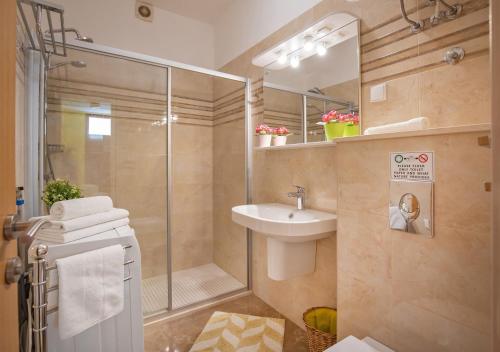 y baño con ducha, lavamanos y ducha. en Apartment Ploče Marina, en Dubrovnik