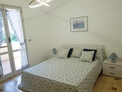 ガリポリにあるAppartamento con giardino sul mareの白いベッドルーム(ベッド1台、窓付)