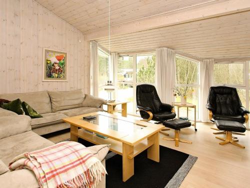 Hedensted - Nordjyllandにある8 person holiday home in lb kのリビングルーム(ソファ、テーブル、椅子付)