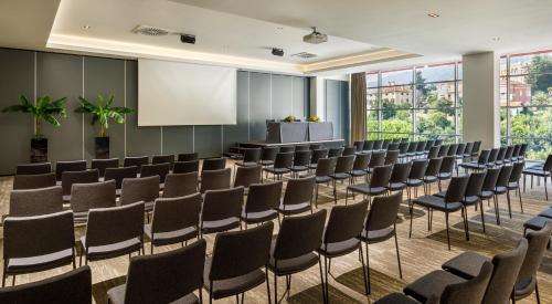 a conference room with chairs and a podium at Hotel Ambasador - Liburnia in Opatija