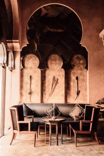 a living room with a couch and a table and chairs at Amanjena Resort in Marrakech