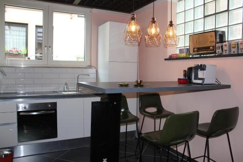 a kitchen with a counter and some chairs in it at BLUE SKY-Suite in Fellbach