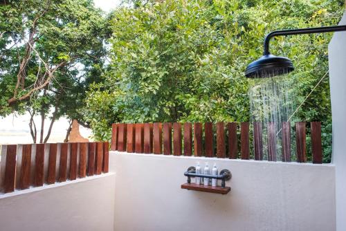 a water fountain on a wall next to a fence at Sausage Tree Camp in Jeki