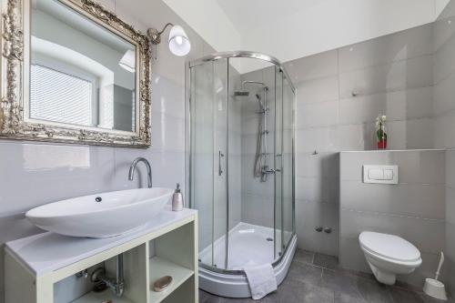 a bathroom with a sink and a shower and a toilet at Captain Emo City Apartments in Pula