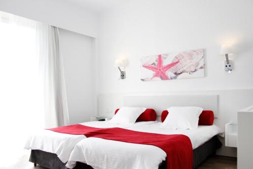 a bedroom with two beds with red and white sheets at Morlans Garden in Paguera