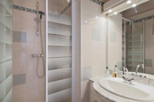 a white bathroom with a sink and a shower at Appartement Moustier - Welkeys in Avignon
