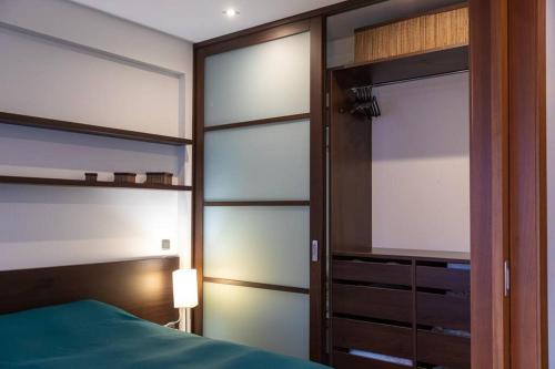 a bedroom with a bed and a sliding glass door at Cozy river-side apartment right in Riga in Rīga