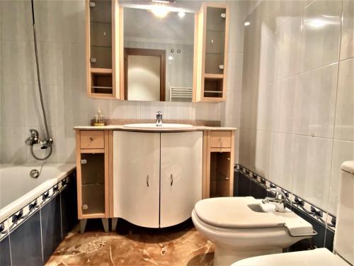 un bagno con lavandino, WC e specchio di Housingleón - San Marcos con garaje a León