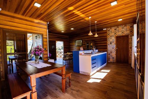ein Wohnzimmer mit einem Tisch und einer Küche in der Unterkunft Chalé Família - Sítio Vale Encantado in Treviso