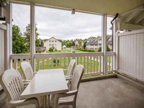 d'une table et de chaises sur un balcon avec vue sur une maison. dans l'établissement Dünenpark Binz - Komfort Ferienwohnung mit 1 Schlafzimmer und Balkon im Obergeschoss 120, à Binz