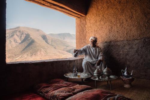 a man sitting in a room with a view of a mountain at Amanjena Resort in Marrakech