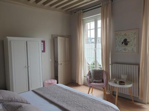 sypialnia z łóżkiem, stołem i krzesłem w obiekcie Les Fougères w mieście Honfleur