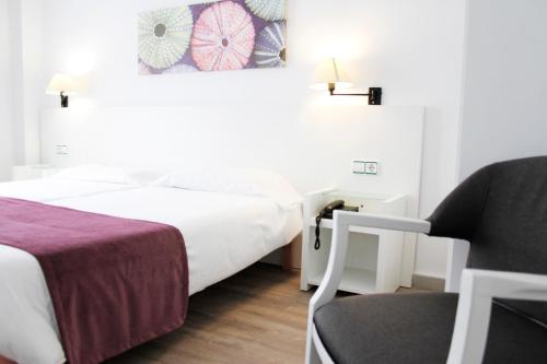 a hotel room with a bed and a chair at Morlans Garden in Paguera