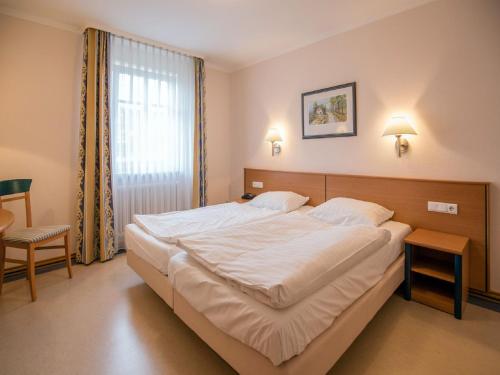 - une chambre avec un grand lit blanc et une fenêtre dans l'établissement Dünenpark Binz - Komfort Ferienwohnung mit 1 Schlafzimmer und Balkon im Obergeschoss 132, à Binz