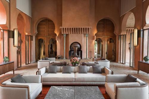 a living room with couches and tables in a building at Amanjena Resort in Marrakech
