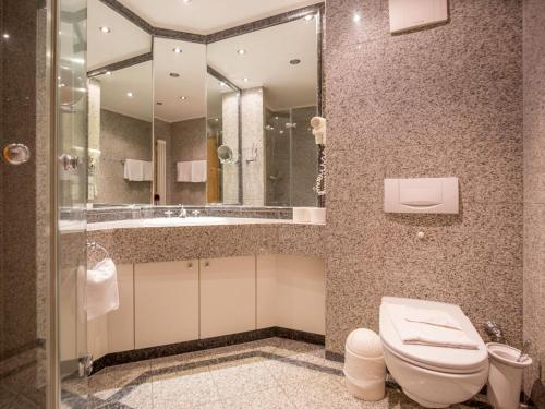 a bathroom with a toilet and a sink and a mirror at Dünenpark Binz - Komfort Ferienwohnung mit 1 Schlafzimmer und Balkon im Dachgeschoss 147 in Binz