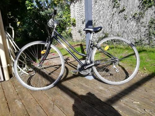 un vélo est garé sur une terrasse en bois dans l'établissement Maison RONCE LES BAINS, à Ronce-les-Bains