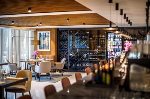 a restaurant with tables and chairs and a wine cellar at Hotel Ambasador - Liburnia in Opatija