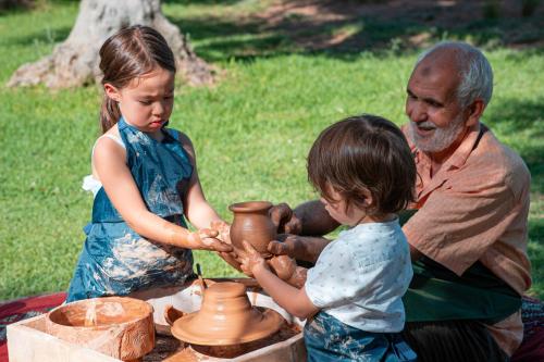 a man and a little girl making pottery at Amanjena Resort in Marrakech