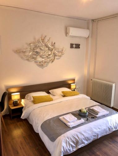 a bedroom with a large white bed with yellow pillows at Lemon Tree Inn in Markopoulo