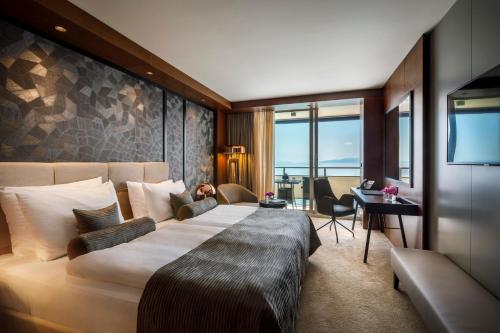 奧帕蒂亞的住宿－Hotel Ambasador - Liburnia，酒店客房设有一张大床和一张书桌。