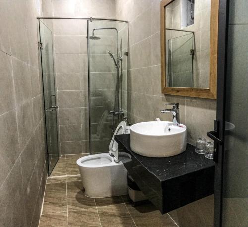 y baño con lavabo, ducha y aseo. en Khách sạn Sky, en Bao Loc