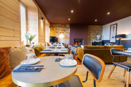 グロワにあるTy Mad Hôtelのテーブル、椅子、ソファ付きのレストラン