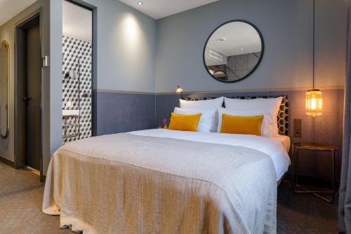 een slaapkamer met een groot bed en een grote spiegel bij Postboutique Hotel Wuppertal in Wuppertal